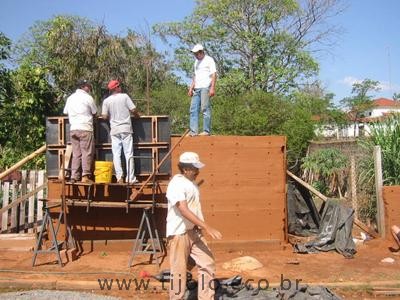 Processo construtivo de parede monolítica de taipa de pilão usando formas e compactação de solo em estado quase seco.